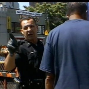 NYPD officer confiscates a sidewalk bookseller's books in New York during New York mayor Rudy Giuliani's controversial 'Quality of Life' campaign, as seen in the New York bookseller documentary, 'BookWars'